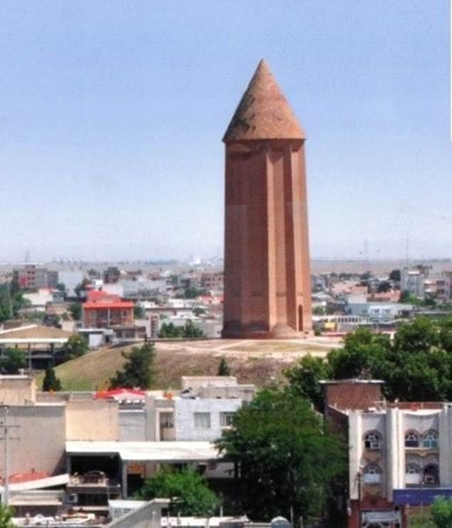 A large clock tower towering over a city

Description automatically generated